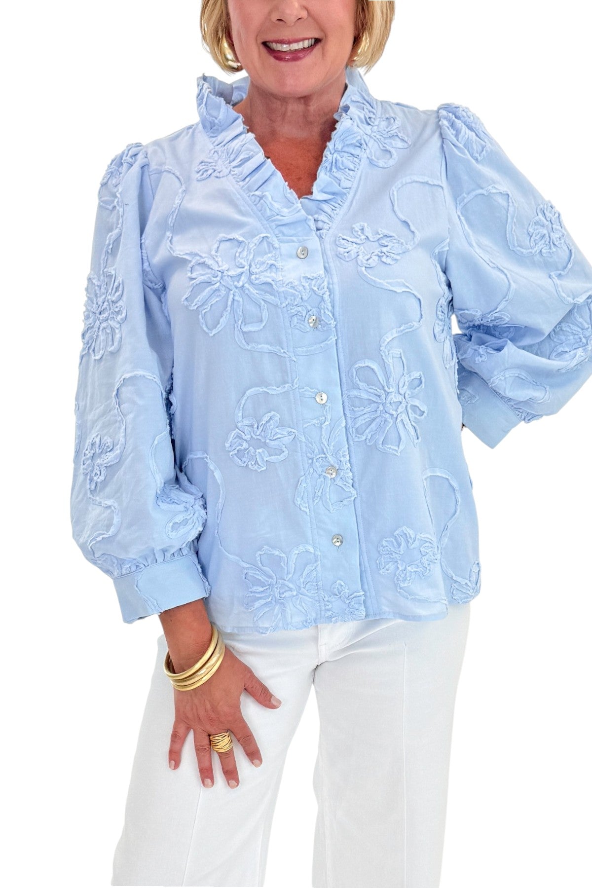 Front detail view of woman wearing Swagger Boutique’s Light Blue Floral 3/4 Sleeve Embroidered Top with jeans against white studio background.