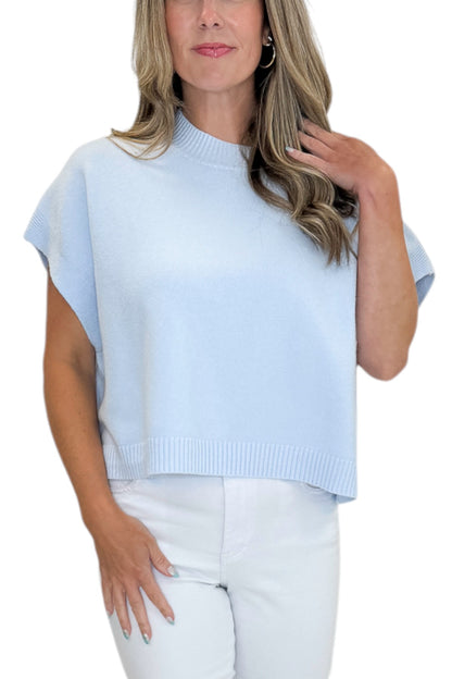 Front detail view of woman wearing Swagger Boutique’s Light Blue Light Weight Short Sleeve Sweater with jeans against white studio background.