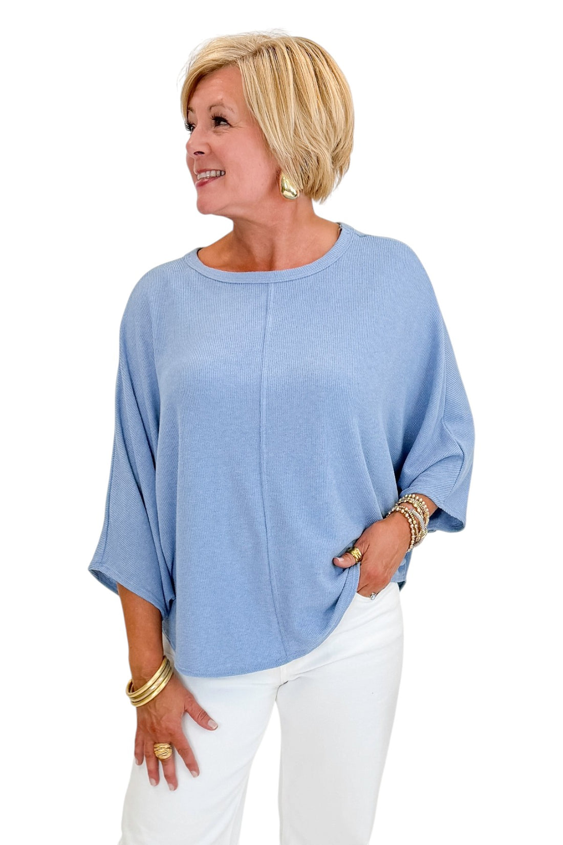 Front view of woman wearing Swagger Boutique’s Light Blue Ribbed Dolman Sleeve Top with jeans against white studio background.