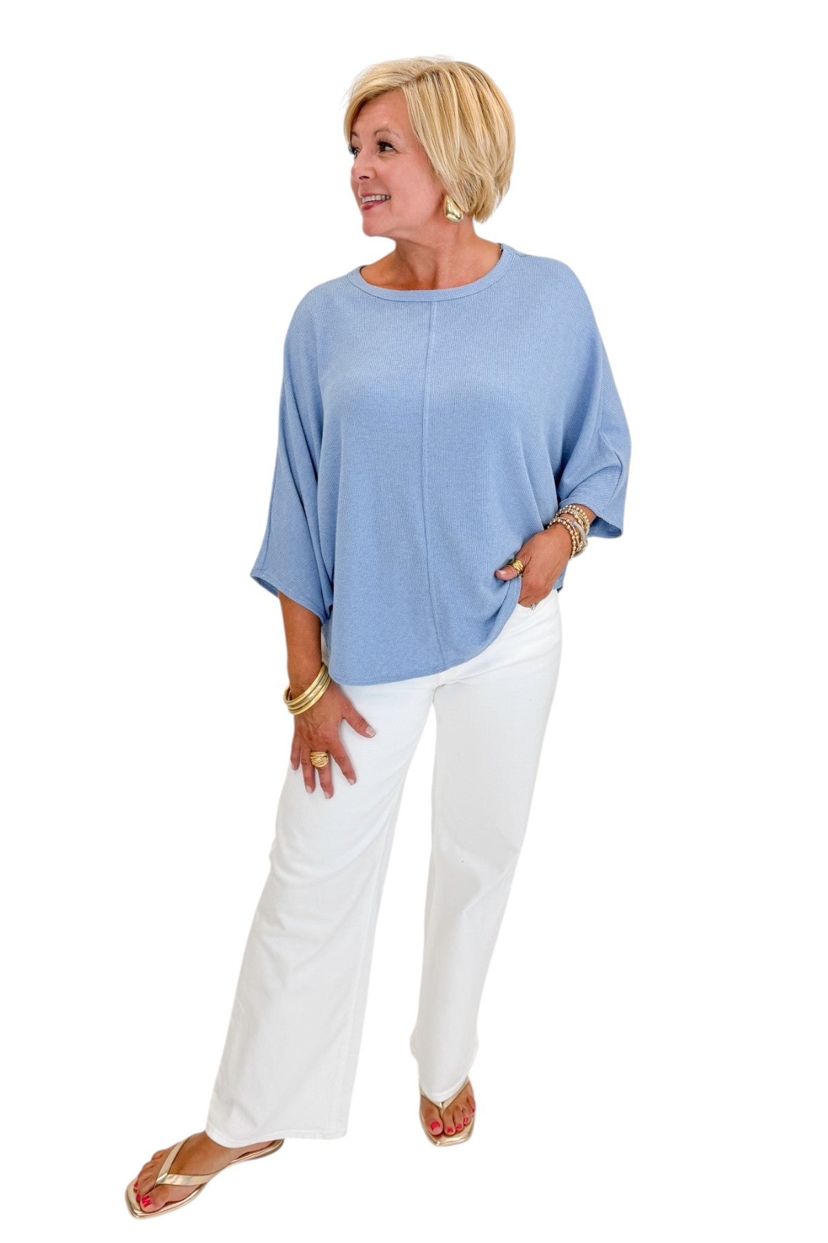 Front view of woman wearing Swagger Boutique’s Light Blue Ribbed Dolman Sleeve Top with jeans against white studio background.