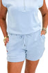 Front detail view of woman wearing Swagger Boutique’s Light Blue Sleeveless 1/4 Zip Top with matching shorts against white studio background.