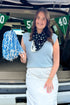Front view of woman wearing Swagger Boutique’s Light Blue Textured Sleeveless Sweater with skirt at a football tailgate.
