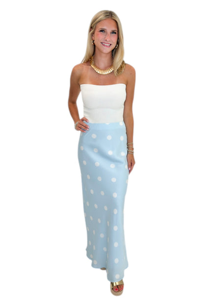 Front view of woman wearing Swagger Boutique’s Light Blue &amp; White Polka Dot Satin Skirt with white top against white studio background.