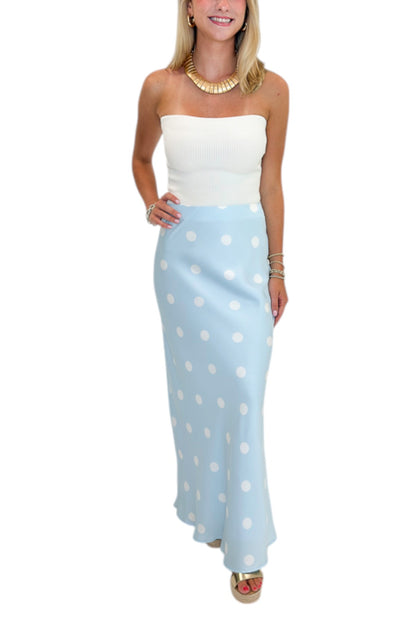 Front view of woman wearing Swagger Boutique’s Light Blue &amp; White Polka Dot Satin Skirt with white top against white studio background.