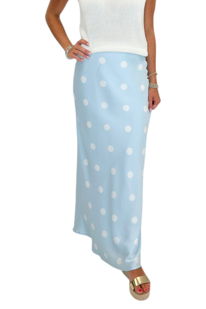 Front detail view of woman wearing Swagger Boutique’s Light Blue &amp; White Polka Dot Satin Skirt with white top against white studio background.