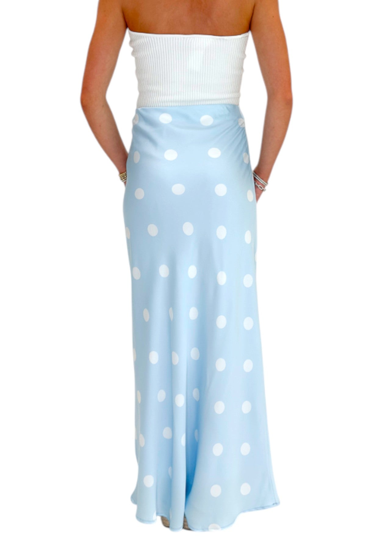 Back view of woman wearing Swagger Boutique’s Light Blue &amp; White Polka Dot Satin Skirt with white top against white studio background.