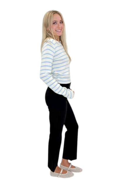 Side view of woman wearing Swagger Boutique’s Light Blue &amp; White Striped Button Up Cardigan with jeans against white studio background.
