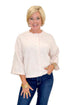 Front view of woman wearing Swagger Boutique’s Light Pink Button Up Short Sleeve Cardigan with jeans against white studio background.