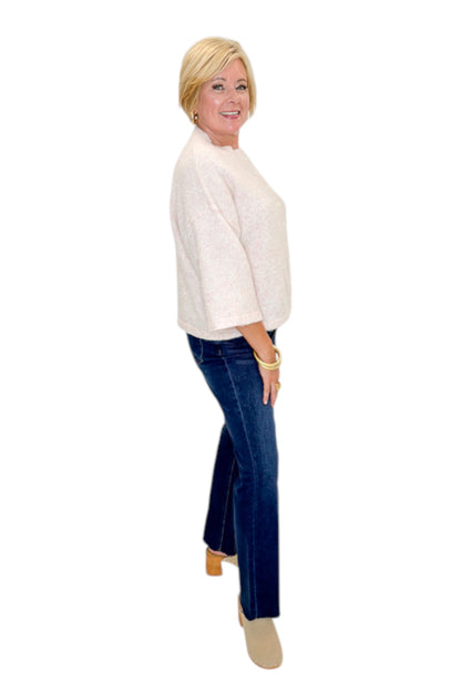 Side view of woman wearing Swagger Boutique’s Light Pink Button Up Short Sleeve Cardigan with jeans against white studio background.