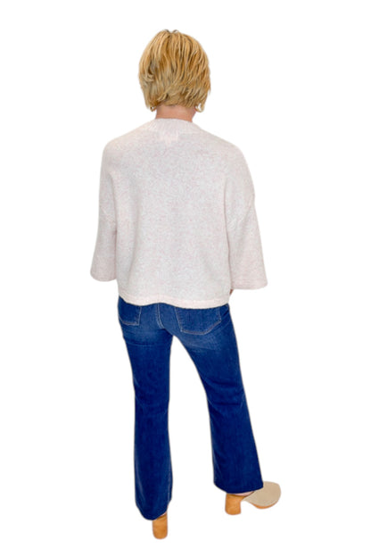 Back view of woman wearing Swagger Boutique’s Light Pink Button Up Short Sleeve Cardigan with jeans against white studio background.