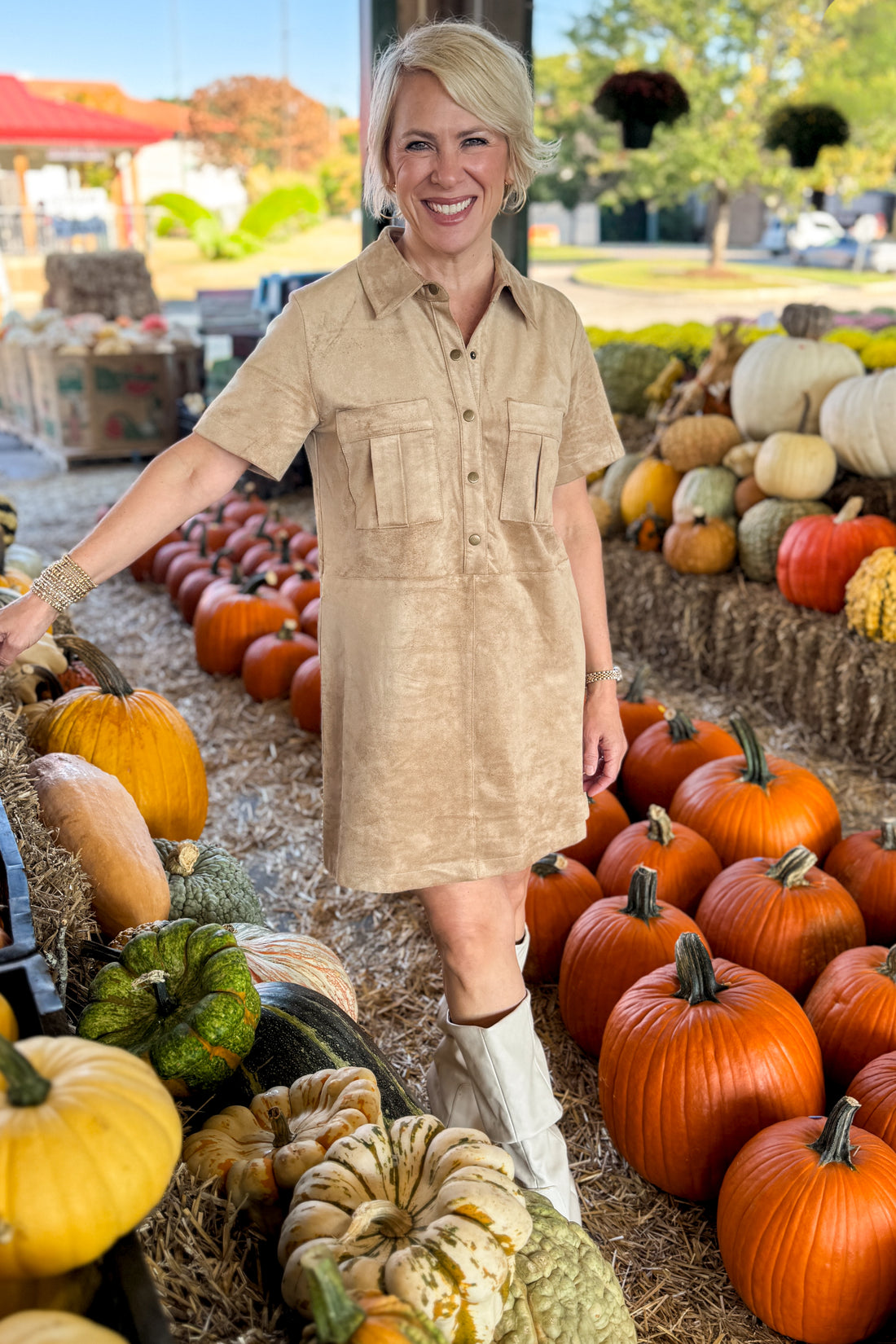 Front view of woman wearing Swagger Boutique’s Light Sand Leone Suede Mini Dress by Zsupply standing at a pumpkin patch.
