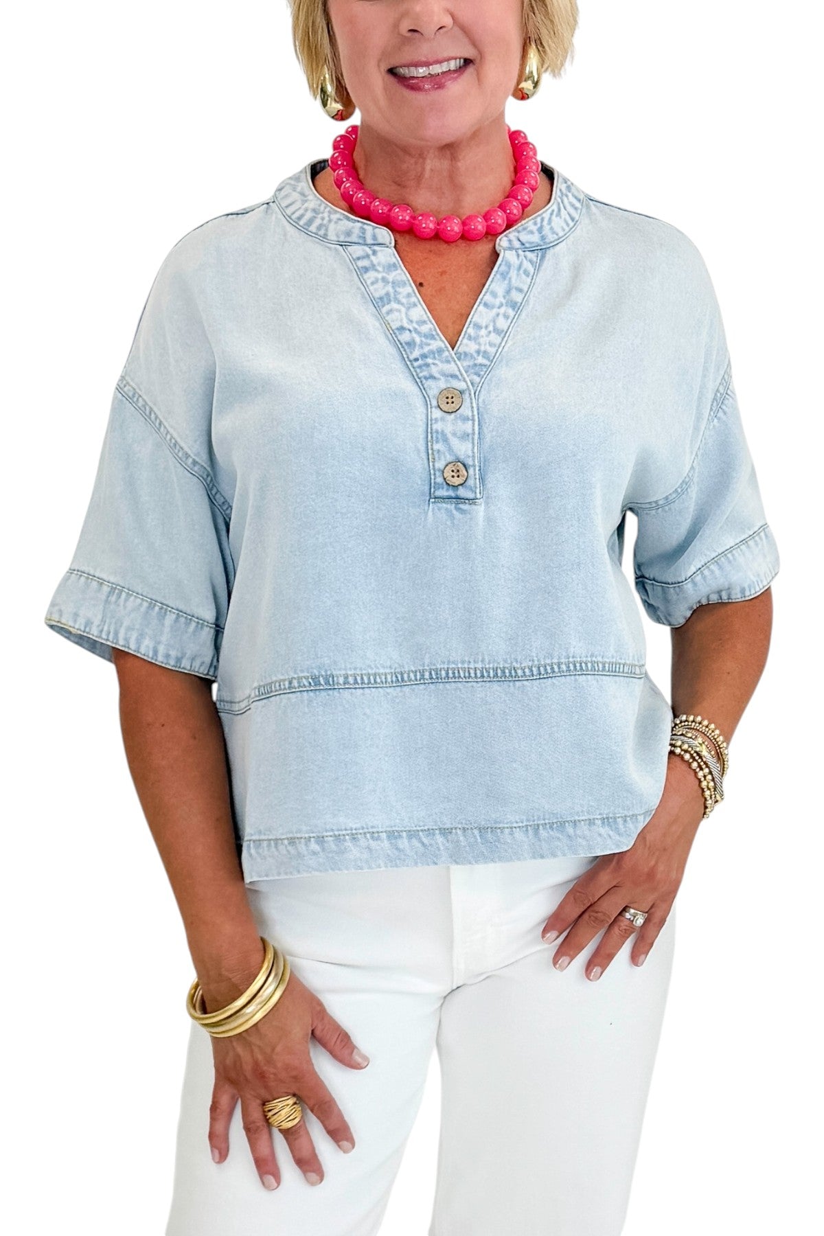 Front detail view of woman wearing Swagger Boutique’s Light Wash Denim V-Neck Top with jeans against white studio background.