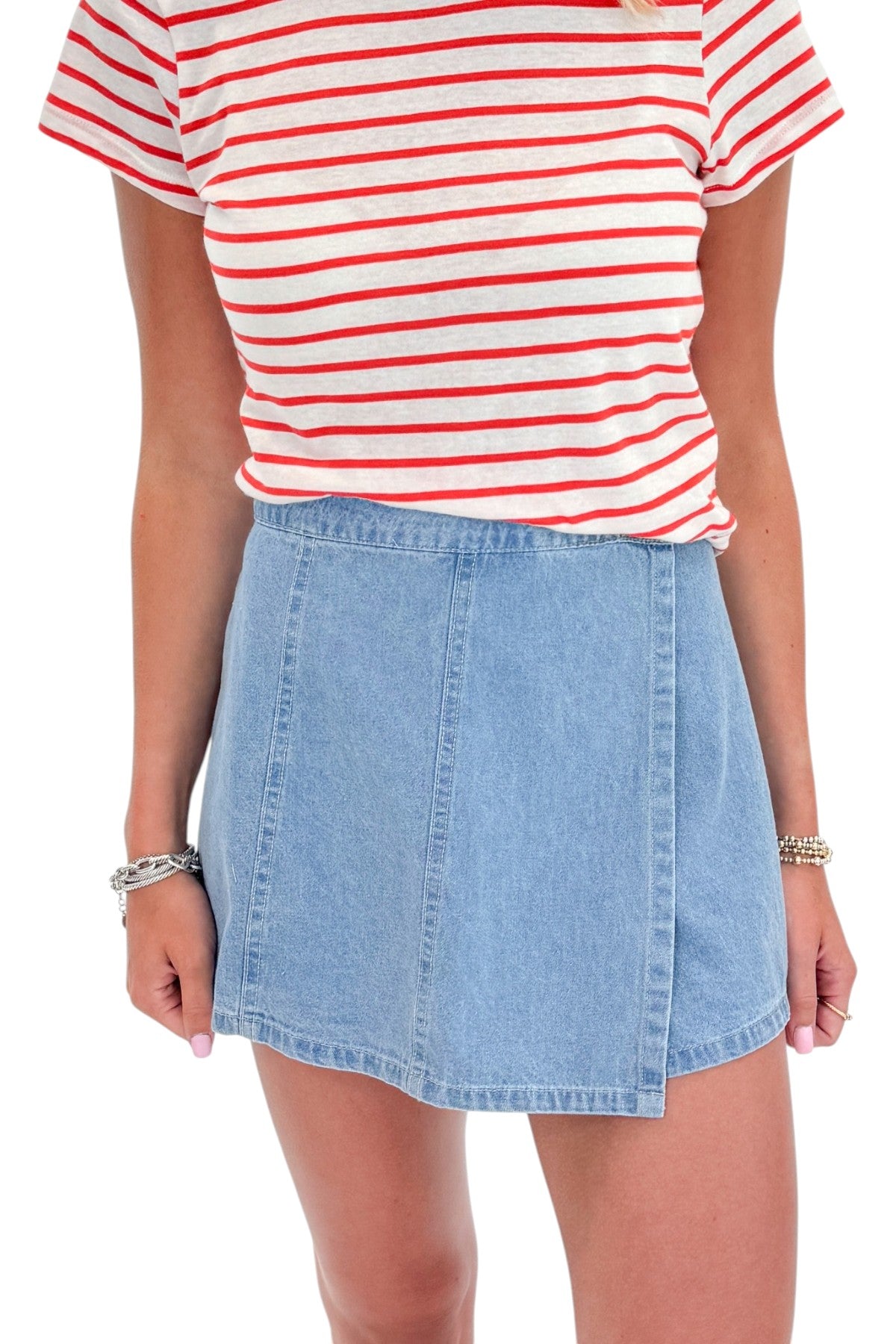 Front detail view of woman wearing Swagger Boutique’s Lychee Junie Striped Tee by Z Supply with Light Wash Denim Wrap Skort against white studio background.