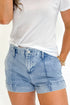 Front view of woman wearing Swagger Boutique’s Light Wash Seamed Denim Shorts with top against white studio background.