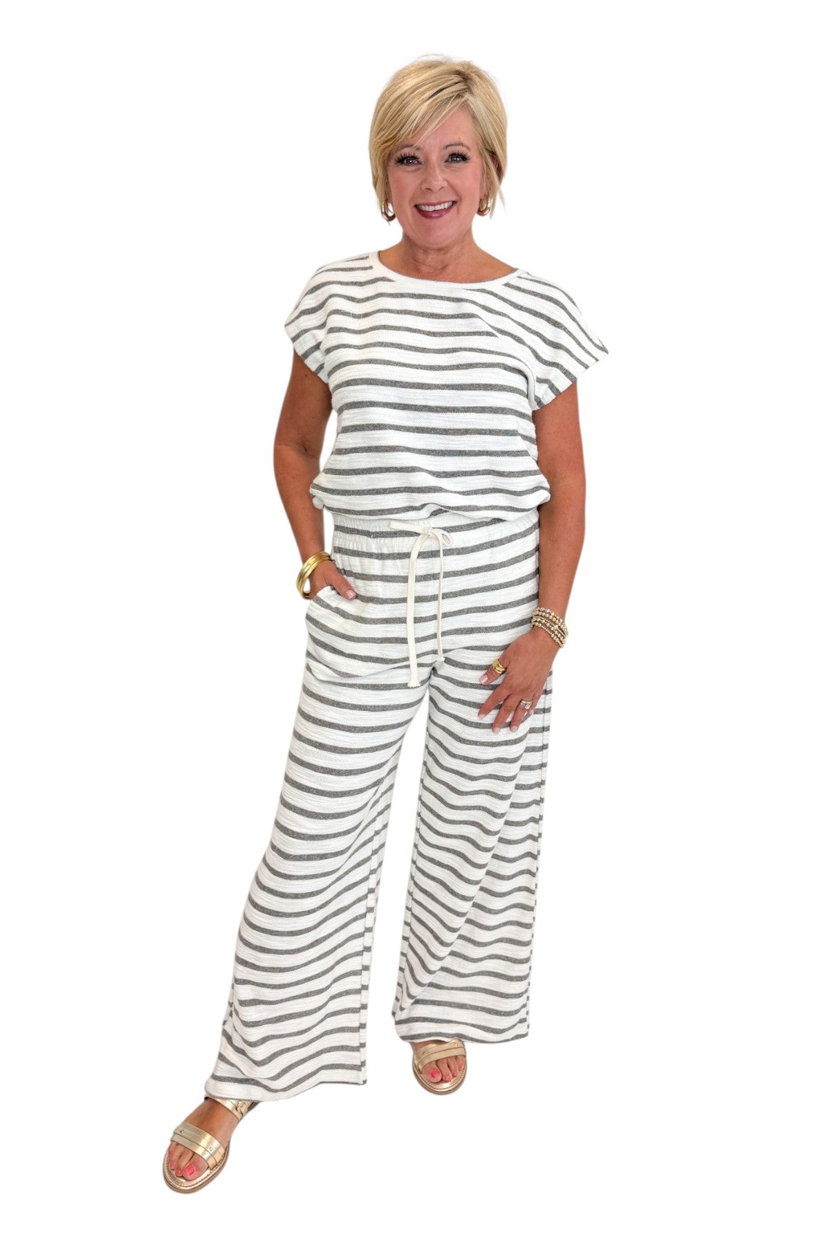 Front view of woman wearing Swagger Boutique’s Light Grey Striped Short Sleeve Top with matching Light Grey Striped Lounge Pants against white studio background.