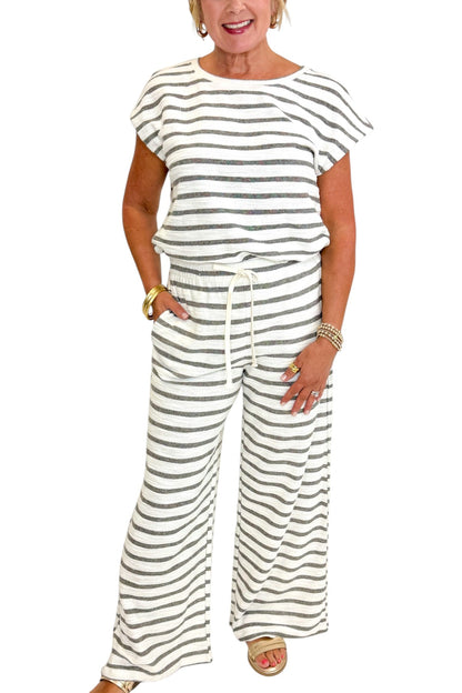 Front detail view of woman wearing Swagger Boutique’s Light Grey Striped Short Sleeve Top with matching Light Grey Striped Lounge Pants against white studio background.