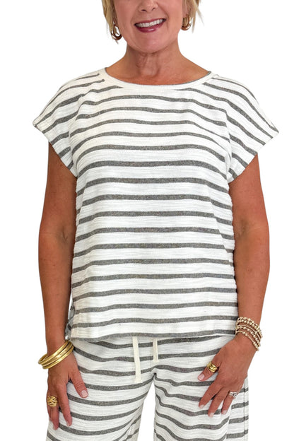 Front detail view of woman wearing Swagger Boutique’s Light Grey Striped Short Sleeve Top with matching Light Grey Striped Lounge Pants against white studio background.