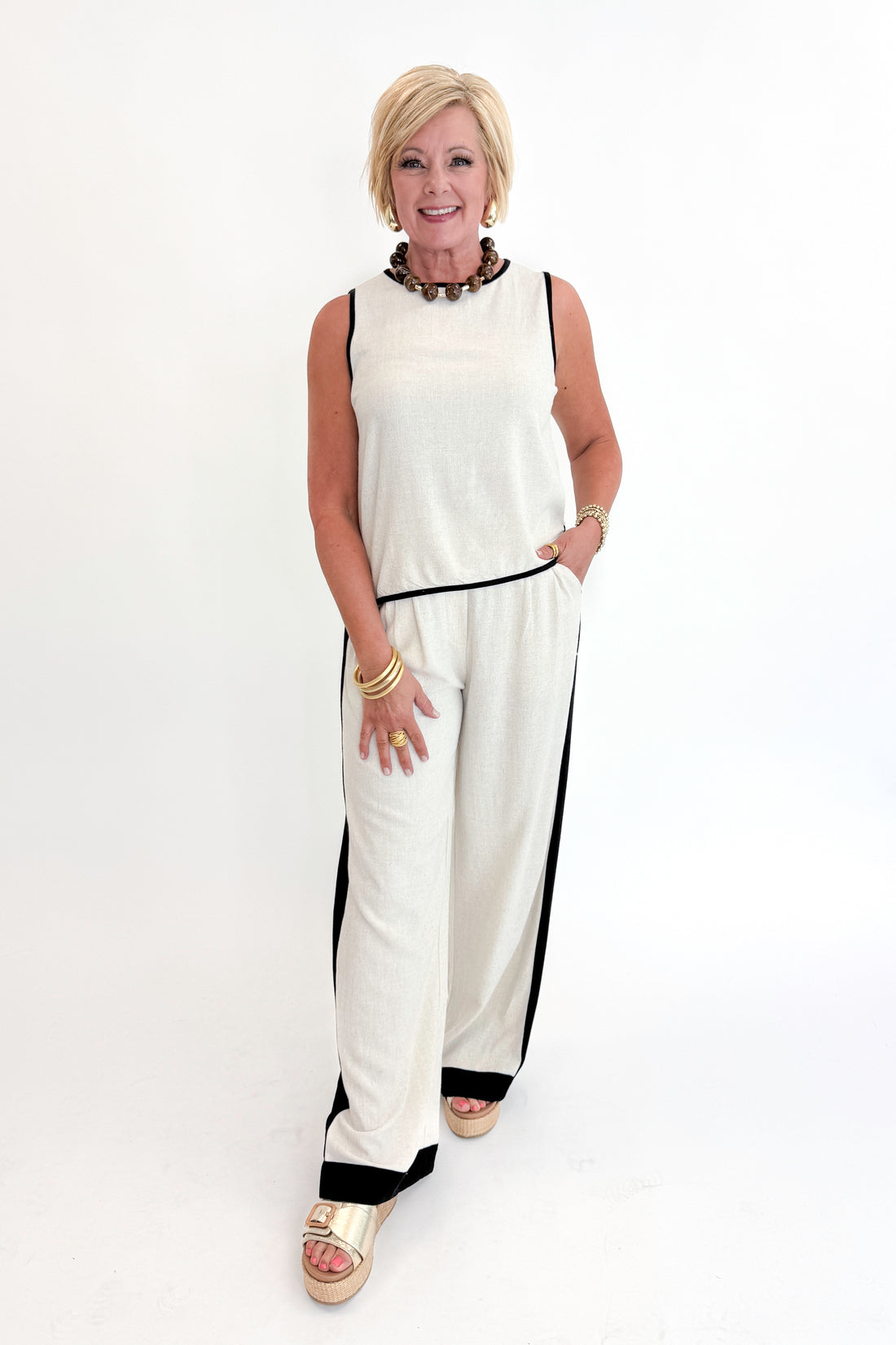 Front view of woman wearing Swagger Boutique’s Linen &amp; Black Lined Tank with matching Linen &amp; Black Stripe Pants against white studio background.