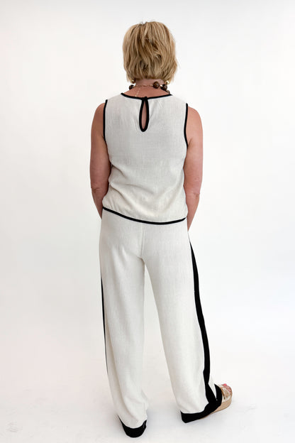Back view of woman wearing Swagger Boutique’s Linen &amp; Black Lined Tank with matching Linen &amp; Black Stripe Pants against white studio background.