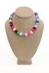 Colorful beaded necklace on a beige mannequin bust against a white background
