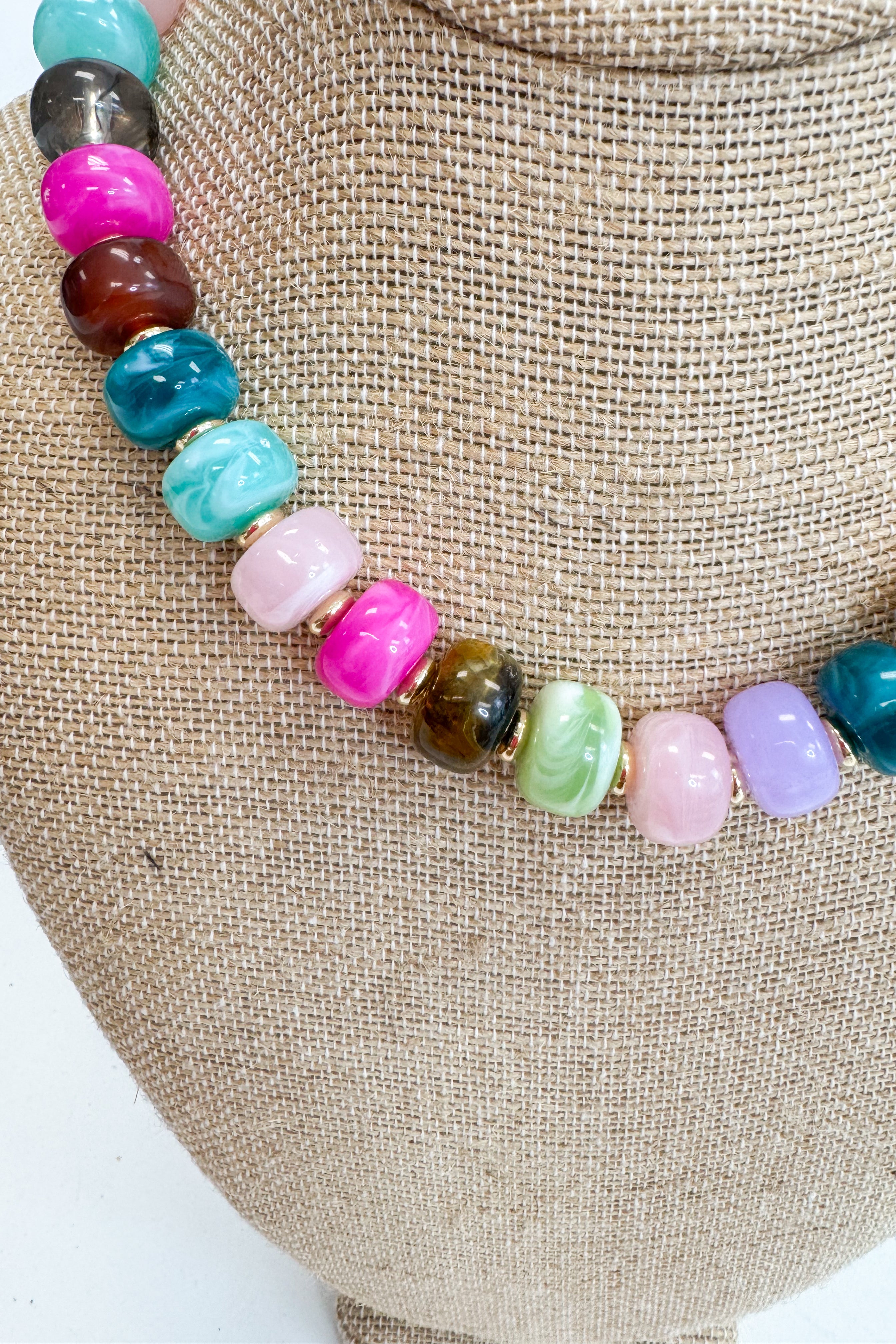 Colorful beaded necklace on a burlap surface