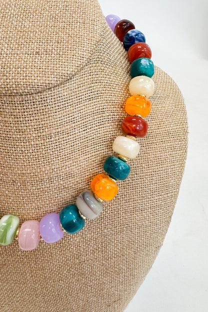 Necklace with multicolored beads on a textured surface