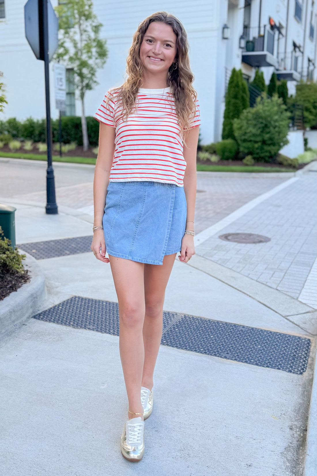 Front view of woman wearing Swagger Boutique’s Lychee Junie Striped Tee by Z Supply with Light Wash Denim Wrap Skort walking outside at a city.