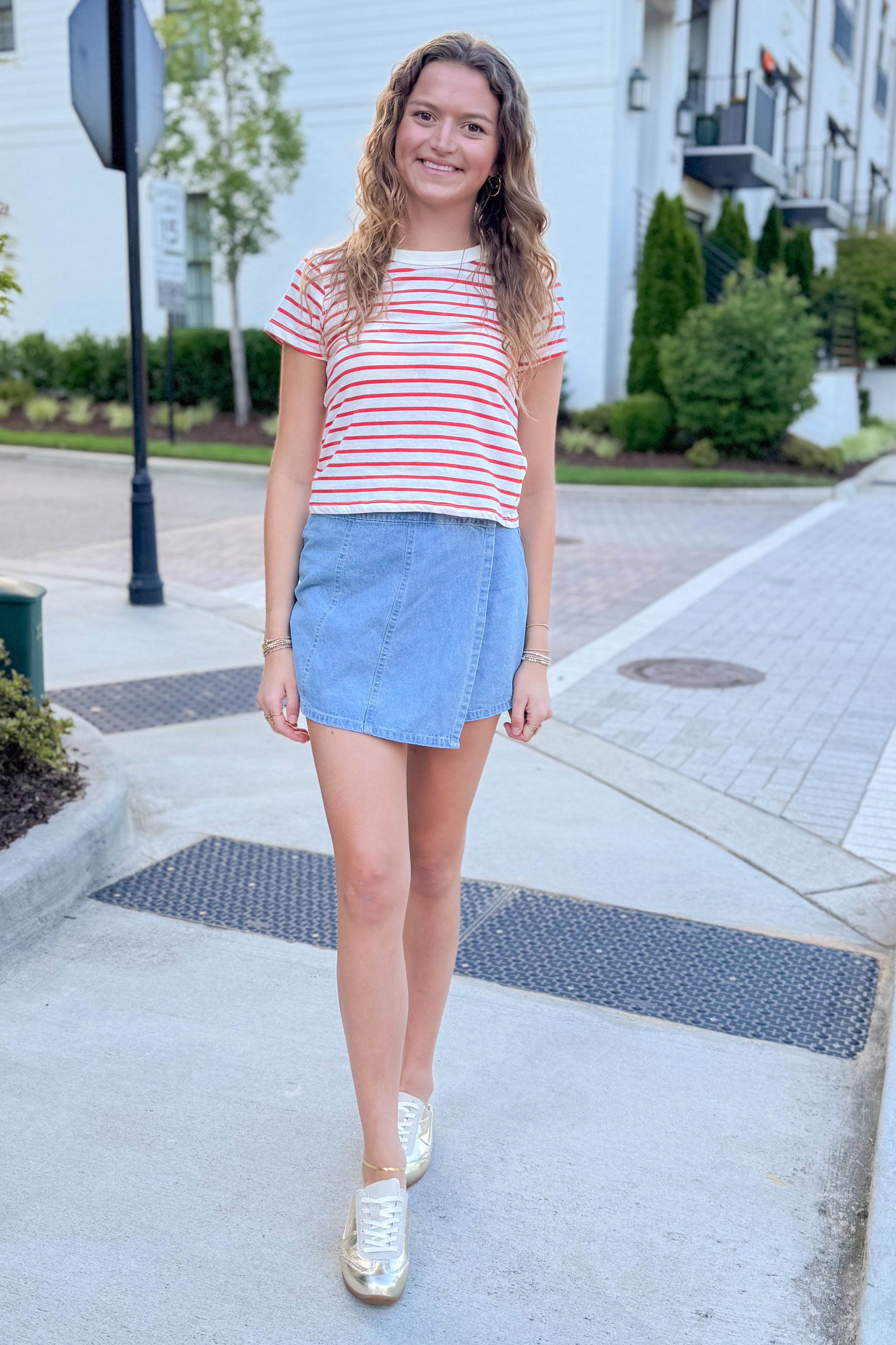 Front view of woman wearing Swagger Boutique’s Lychee Junie Striped Tee by Z Supply with Light Wash Denim Wrap Skort walking outside at a city.
