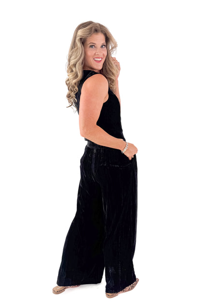 Side view of woman wearing Velvet V-neck Vest with matching pants against white studio background.