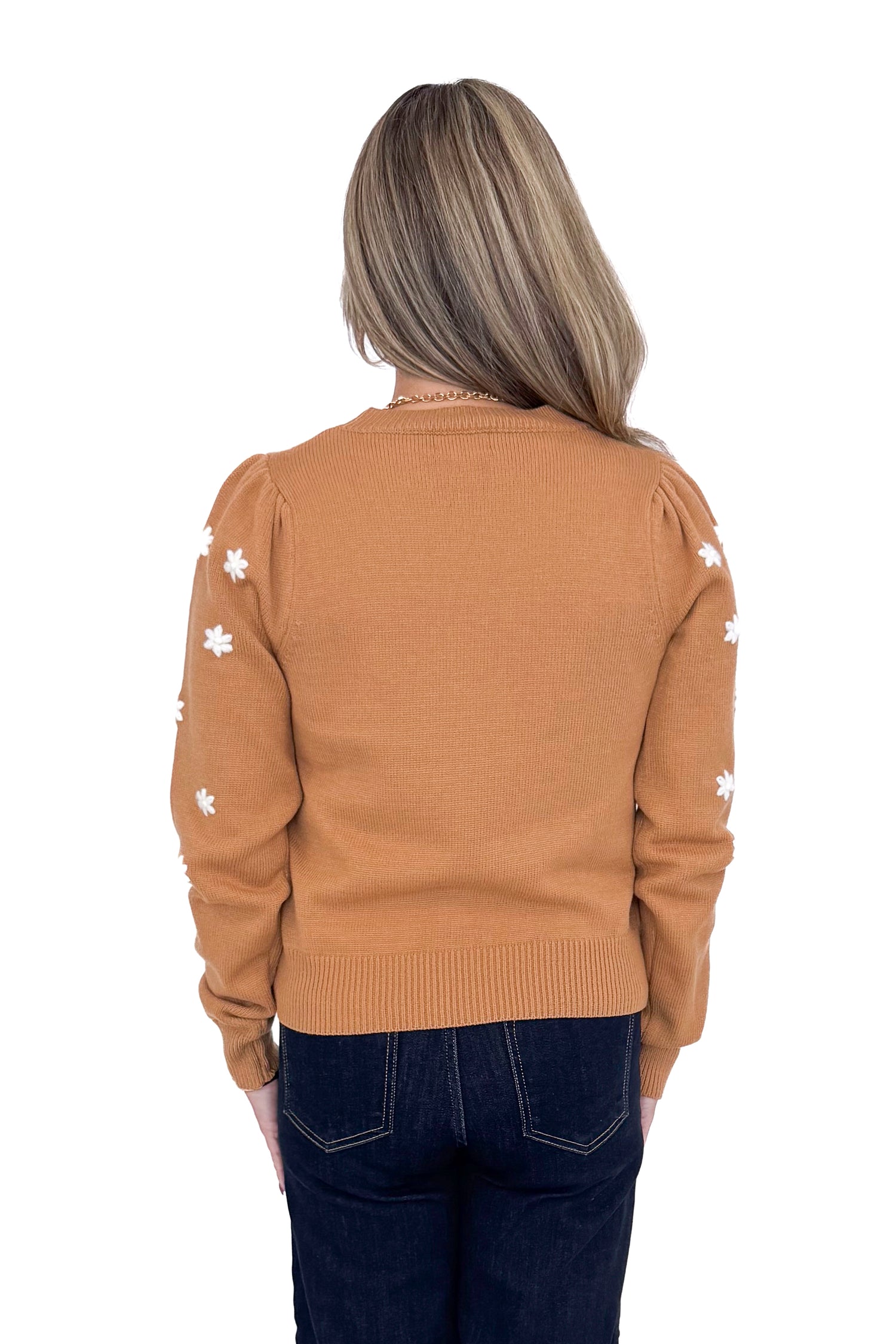 Back view of Woman in studio wearing Taupe With Embroidered Floral Sleeve Sweater and blue jeans with white background. 