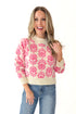 Front view of woman wearing Cream and Pink Floral Patterned Sweater with jeans against white studio background. 