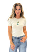 Front view of woman wearing Cream Martini Beaded Ribbed Top with jeans against white studio background.