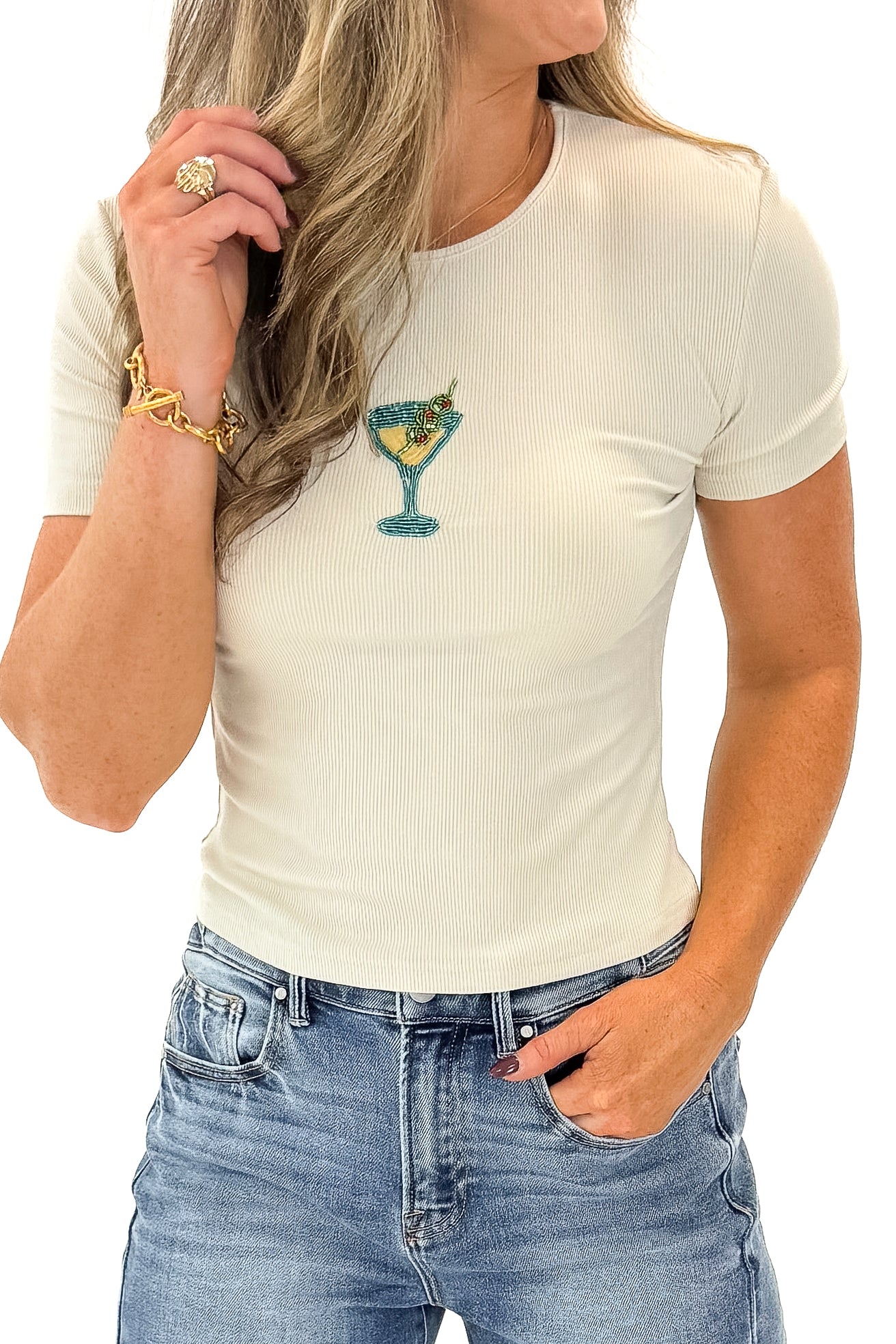 Front detail view of woman wearing Cream Martini Beaded Ribbed Top with jeans against white studio background.
