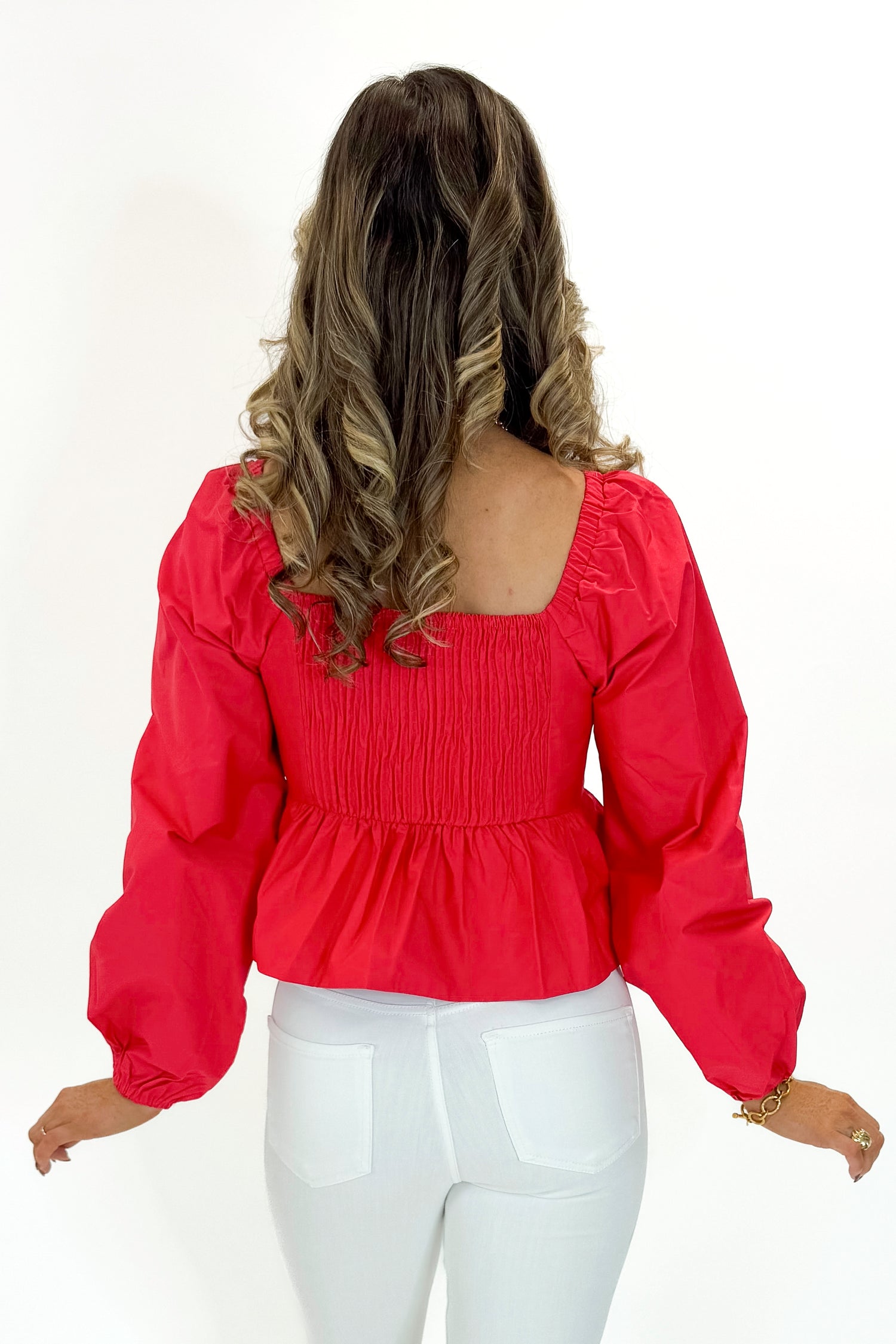 Back view of woman wearing Red Heart Detail Ruffle Top with jeans against white studio background.
