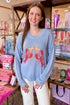 Front view of woman wearing Blue Lobster Graphic Sweater with jeans at a boutique.