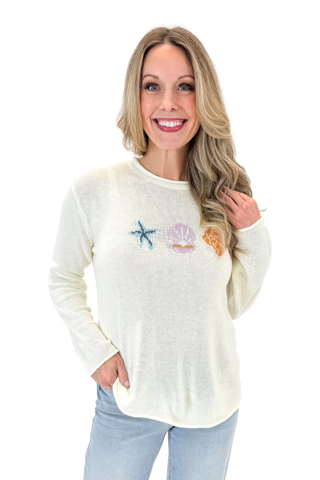 Front view of woman wearing Cream Lightweight Shell Print Sweater with jeans against white studio background.
