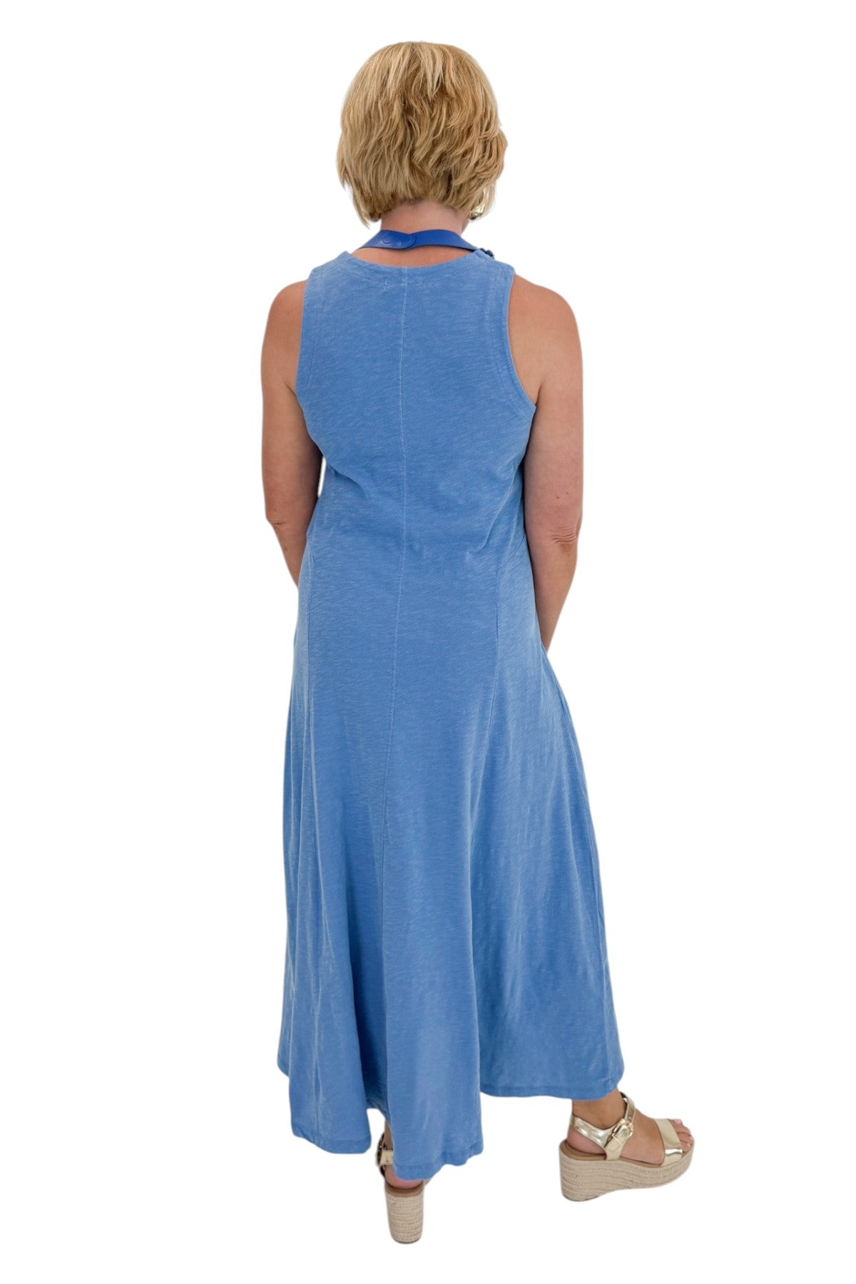 Back view of woman wearing Swagger Boutique’s Marina Waters Edge Midi Dress by Z Supply with sandals against white studio background.