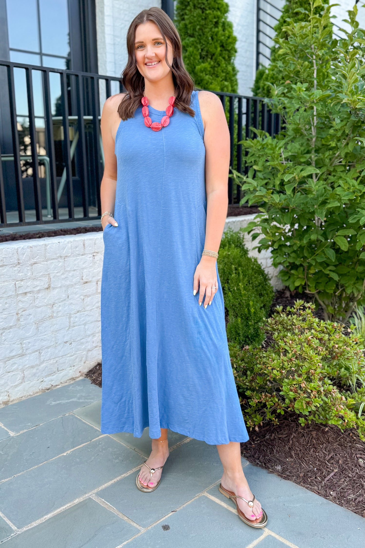 Front view of woman wearing Swagger Boutique’s Marina Waters Edge Midi Dress by Z Supply with sandals standing outside a restaurant.
