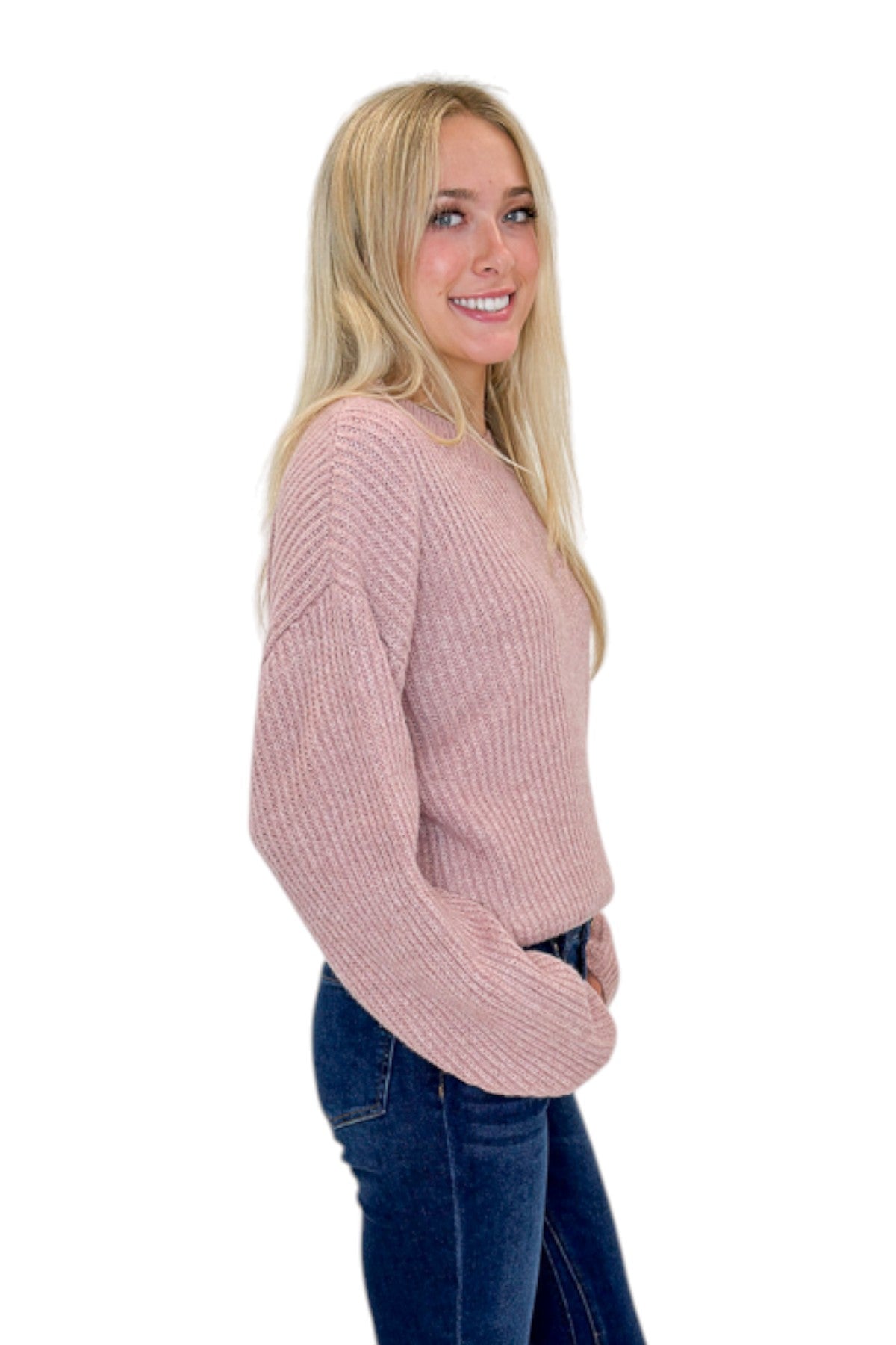 Side view of woman wearing Swagger Boutique’s Mauve Ribbed sweater with jeans against white studio background.
