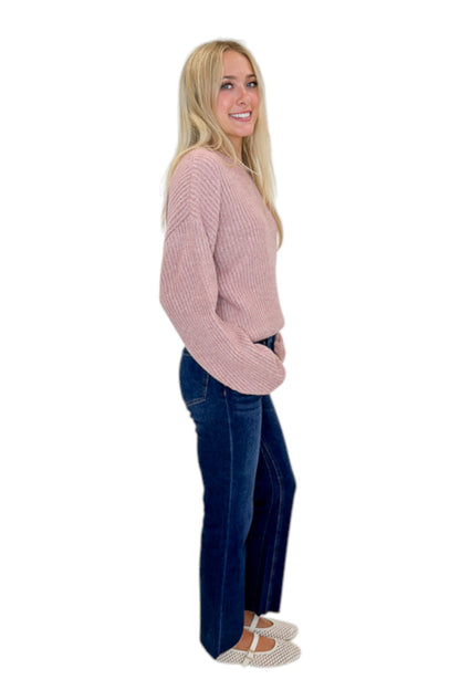 Side view of woman wearing Swagger Boutique’s Mauve Ribbed sweater with jeans against white studio background.