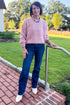 Front view of woman wearing Swagger Boutique’s Mauve Ribbed sweater with jeans standing outside on a brick walkway.