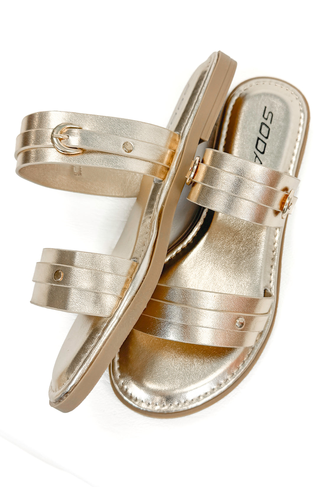 Maya- Gold Double Strap Buckle Detail Sandals against white studio background