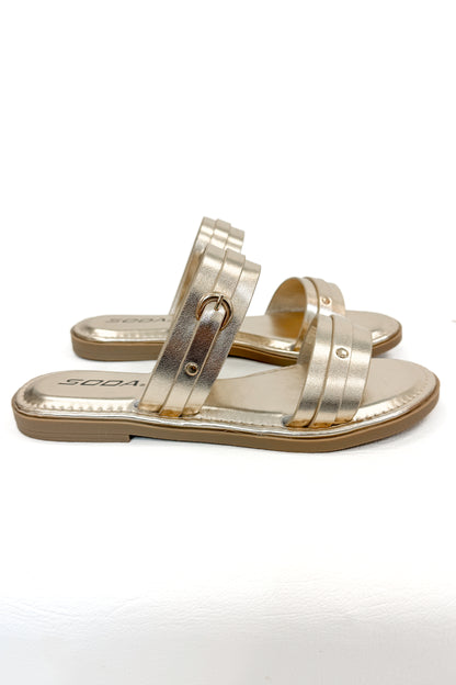 Maya- Gold Double Strap Buckle Detail Sandals against white studio background