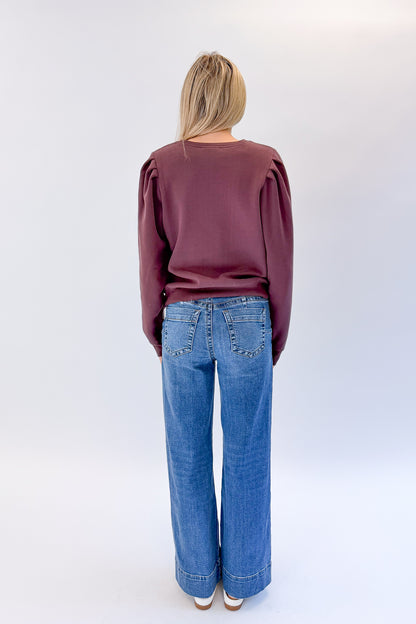 Back view of woman wearing Swagger Boutique’s Maya Wide Leg Jeans In Medium Wash- Journey by Kut from the Kloth against white studio background.