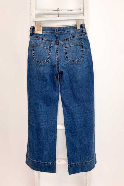 Swagger Boutique’s Maya Wide Leg Jeans In Medium Wash- Journey by Kut from the Kloth hanging against white studio background back view.