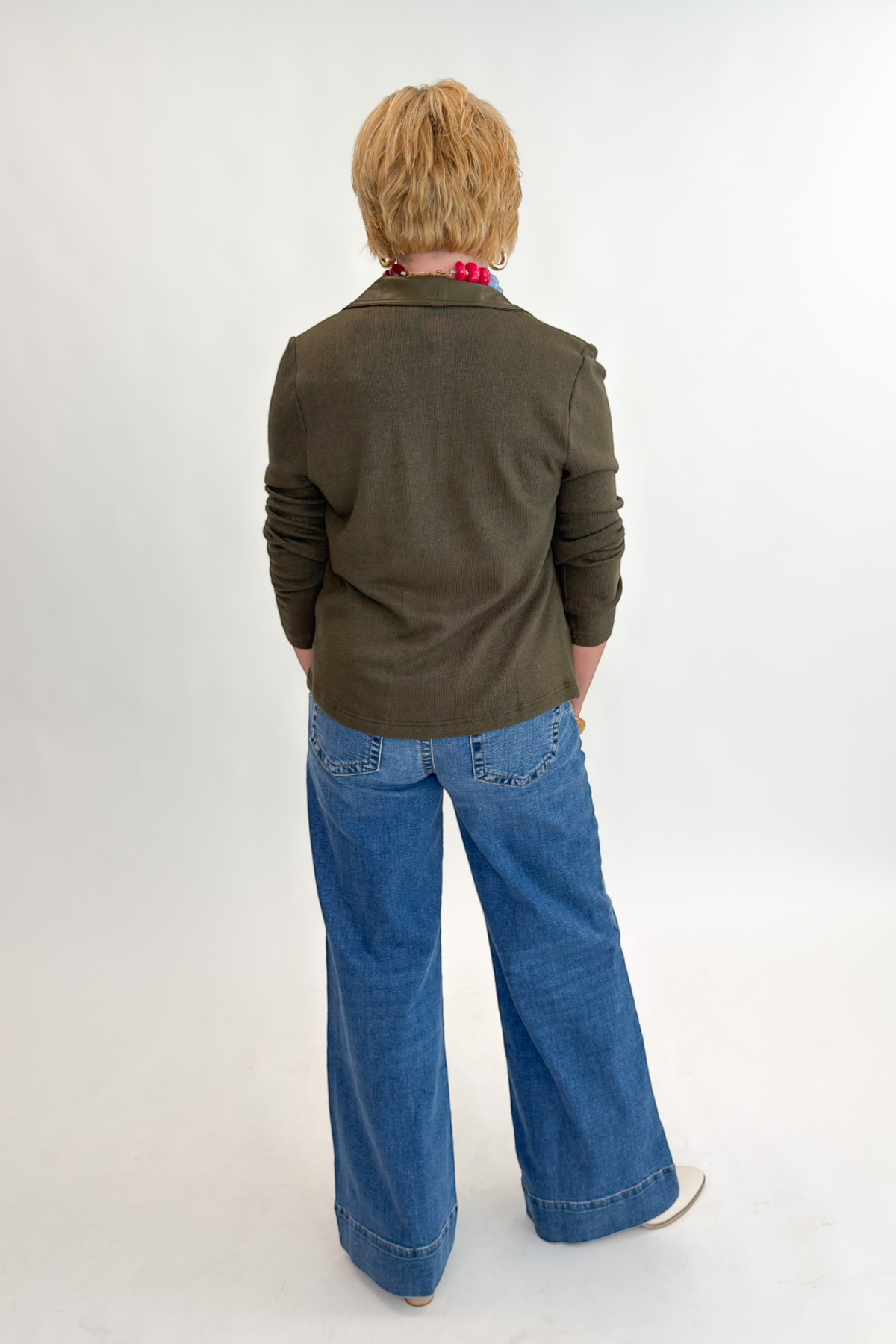 Back view of woman wearing Swagger Boutique’s Maya Wide Leg Jeans In Medium Wash- Journey by Kut from the Kloth against white studio background.