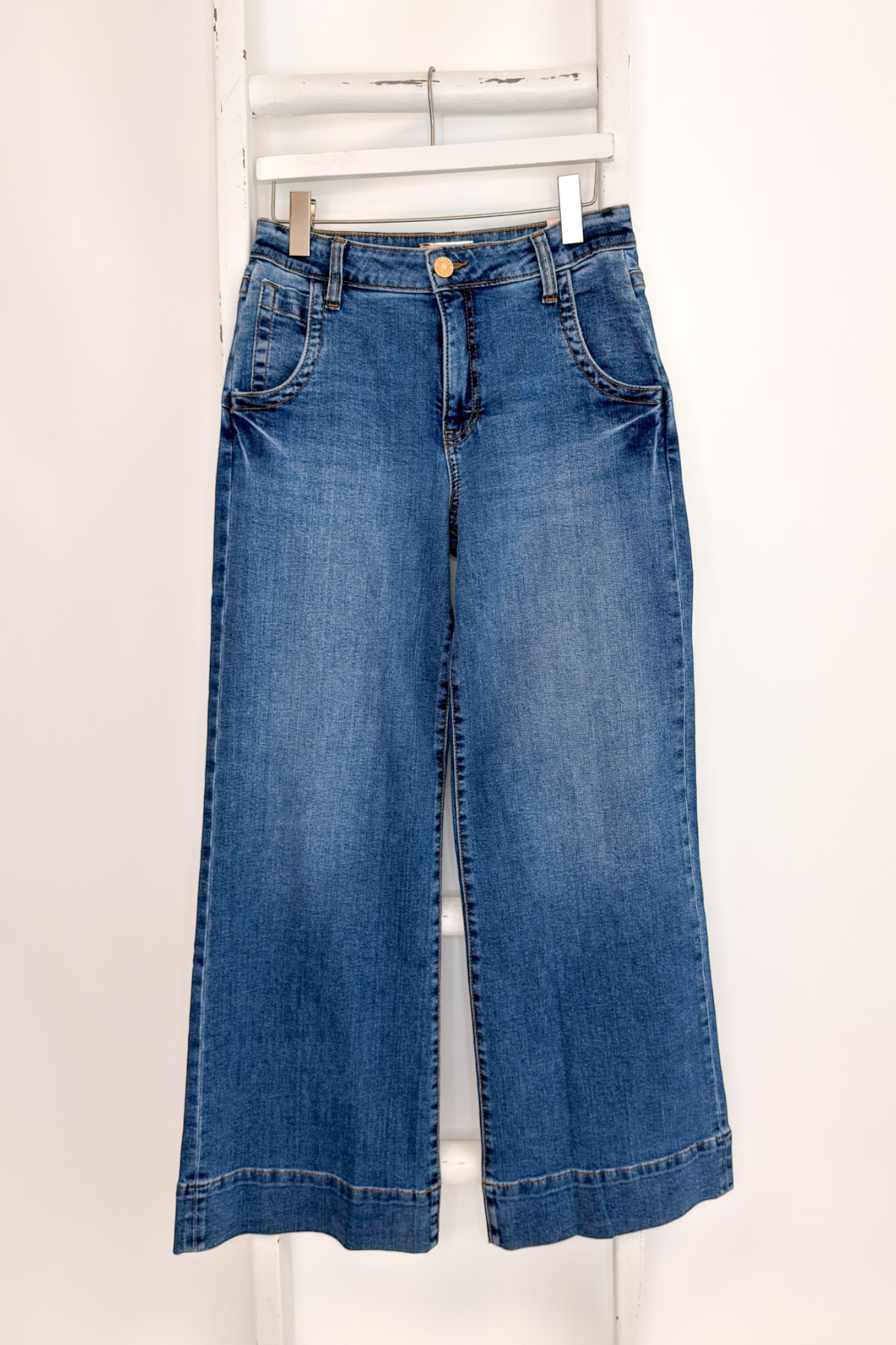 Swagger Boutique’s Maya Wide Leg Jeans In Medium Wash- Journey by Kut from the Kloth hanging against white studio background.
