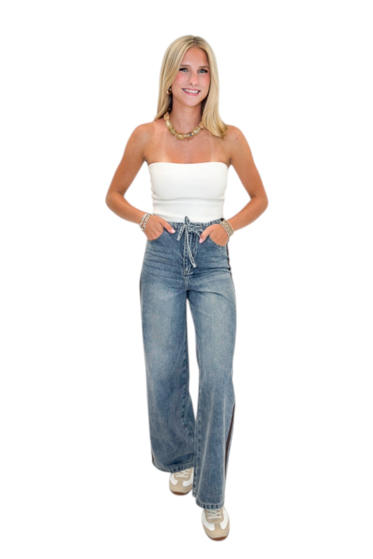 Front view of woman wearing Swagger Boutique’s Medium Wash Brown Stripe Detail Jeans against white studio background.