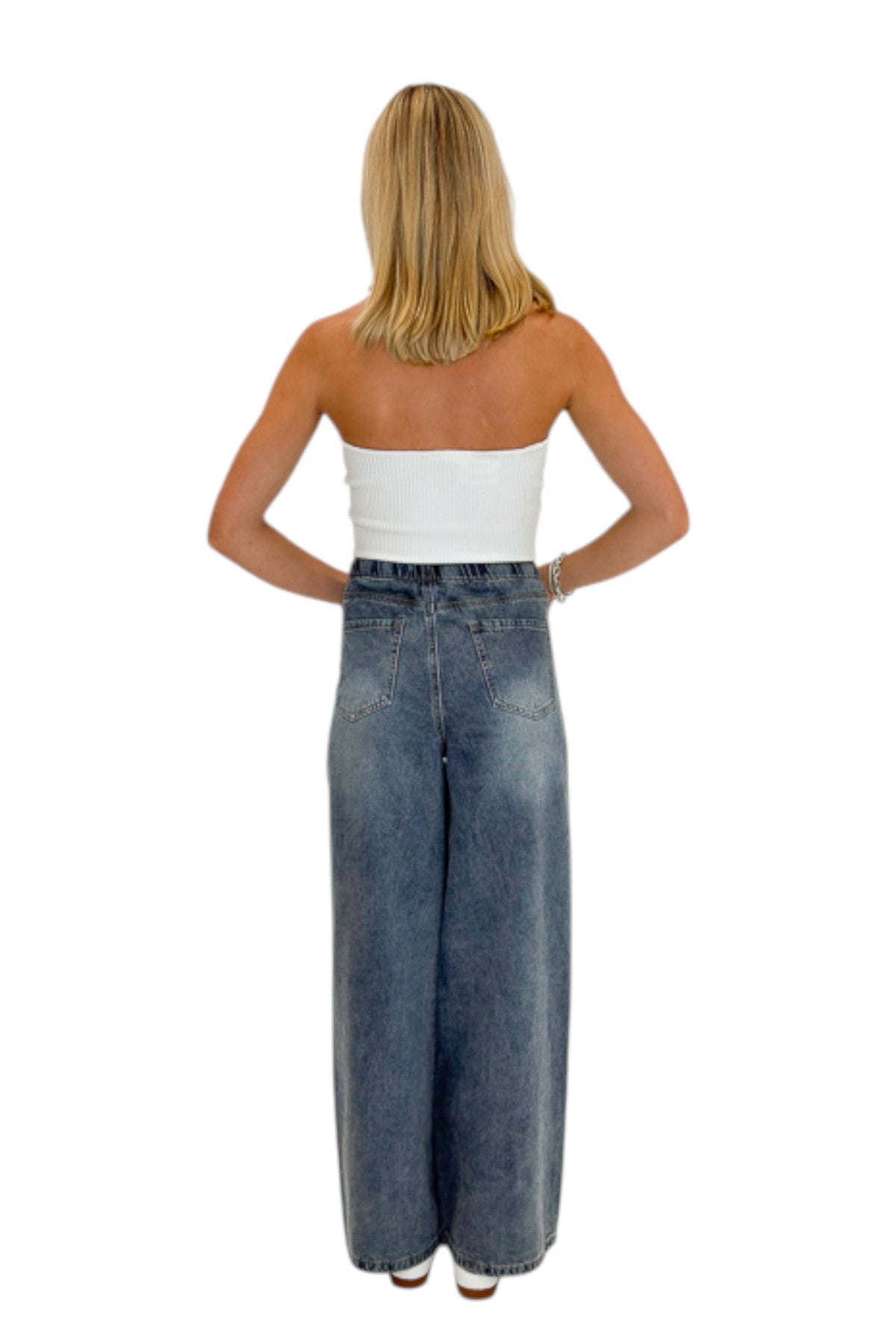 Back view of woman wearing Swagger Boutique’s Medium Wash Brown Stripe Detail Jeans against white studio background.