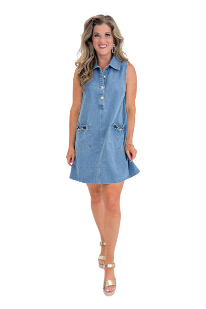 Front view of woman wearing Swagger Boutique’s Medium Wash Sleeveless Denim Midi Dress by Entro with sandals against white studio background.